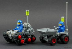 two legos are sitting in front of each other on their wheels, one is pulling a wheelbarrow