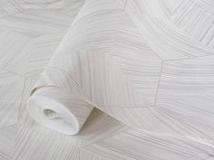 an up close shot of a white wallpaper with wavy lines on the paper and fabric