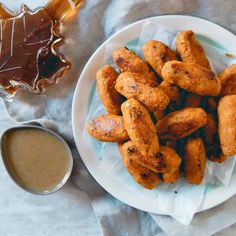 some fried food on a white plate next to dipping sauce