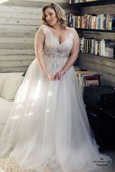 a woman in a white wedding dress standing next to a bookshelf