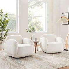 a living room with two white chairs and a table in front of a window on top of a rug