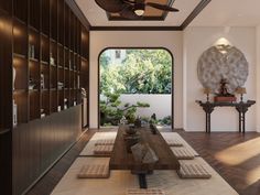 a living room filled with furniture and a large window next to a wooden table on top of a hard wood floor