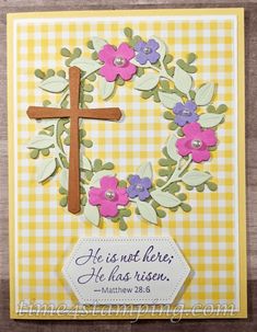 a card with a cross on it and flowers in the middle, saying he is not here