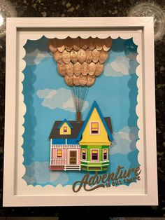 a paper cut out of a house with coins hanging from it's roof and the words adventure is over