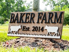 a sign that says baker farm est 2014 on it in front of some grass and trees