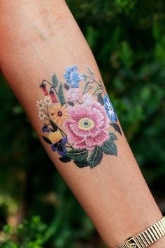 a close up of a person's arm with flowers painted on the side of it