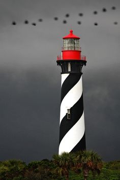 a black and white lighthouse with red top