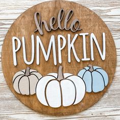 a wooden sign that says hello pumpkin with white and blue pumpkins in the background