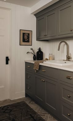 a kitchen with gray cabinets and white walls