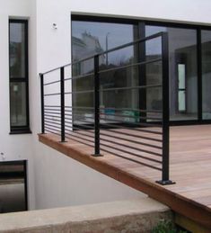 an outside view of a house with glass doors and metal railings on the balcony