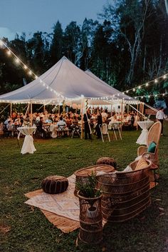 a large tent with tables and chairs set up for an outdoor dinner party in the evening