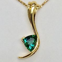 Studio Jewelers on Instagram: “This glamorous pendant by Tom Dailing showcases a glorious blue-green tourmaline and 18k yellow gold”