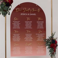 a red and gold wedding seating chart with flowers