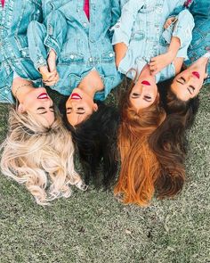 three women with painted faces laying on the ground in front of their heads and hands