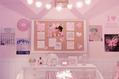 there is a pink room with pictures on the wall and decorations hanging above the desk