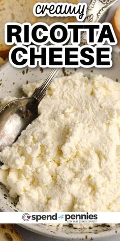 a white bowl filled with ricotta cheese on top of a table next to bread