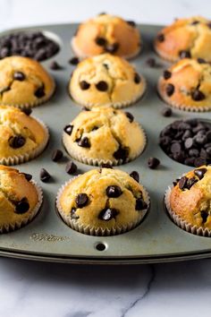 muffins with chocolate chips in them sitting on a baking tray, ready to be eaten