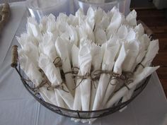 a basket filled with white napkins on top of a table