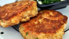 two crab cakes sitting on top of a white plate