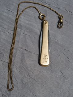 a knife on a chain with the initials f and f