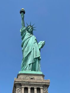 the statue of liberty stands tall in front of a clear blue sky with no clouds