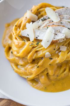 a white plate topped with pasta covered in cheese