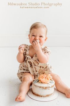 a baby sitting on the floor eating cake