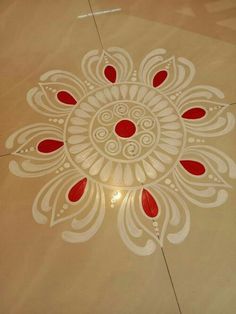 a white and red design on the floor in a room with light coming through it