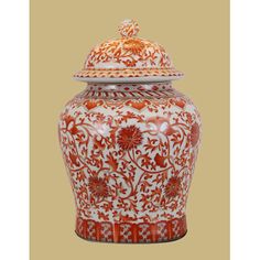 an orange and white vase with a lid