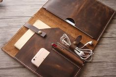 an ipad case with earbuds and cords attached to it on top of a wooden table