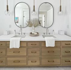 a bathroom with two sinks and three mirrors