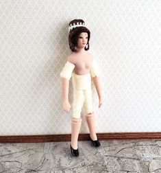 a doll is standing in front of a wall