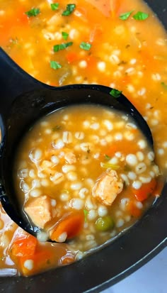 two spoons filled with soup on top of a table