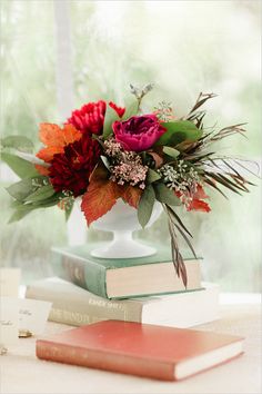 a vase filled with flowers sitting on top of two books