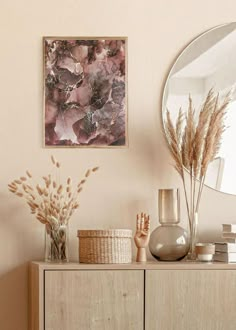 a wooden dresser topped with lots of vases and plants next to a round mirror