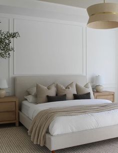 a bedroom with a large bed and white walls