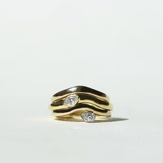 two gold rings with diamonds sitting on top of each other