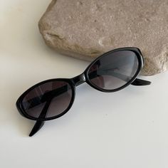 These round oval sunglasses are your everyday go to pair.  Featuring a black frame with smoke lens.  True genuine vintage sunglasses from the 90s.   - 400 uv  - new vintage from the 90s - includes sunglasses pouch  Style:  MINI means small (meant to fit small on face) Measurements:  Lens Height: 33 mm  Lens Width: 48 mm  Bridge: 15 mm  Arm temple: 140 mm Also available in brown tortoise https://etsy.me/2YBcJ4H Affordable Retro Oval Sunglasses, Cheap Elegant Oval Sunglasses, Cheap Trendy Oval Sunglasses, Cheap Vintage Black Sunglasses, Sunglasses For Small Face, Sunglasses For Small Faces, Black Oval Sunglasses, Round Face Sunglasses, Nice Glasses