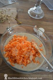 a bowl filled with carrots on top of a wooden table