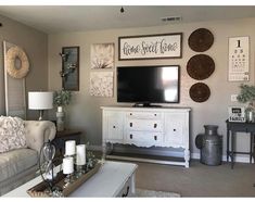 a living room filled with furniture and pictures hanging on the wall above a flat screen tv