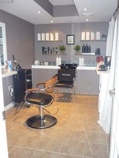 a hair salon with chairs and shelves on the wall