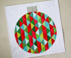 a quilted christmas ornament is shown on the floor next to a piece of paper