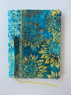 a blue and yellow notebook covered in fabric