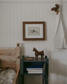 a horse figurine on a small table next to a bed