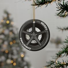 a christmas ornament hanging from a tree with a car wheel on the front