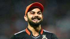 a man with a beard wearing a red hat and black shirt smiles at the camera