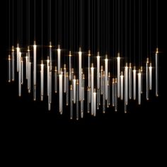 a large number of candles hanging from the ceiling in front of a black background with white lights