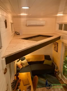 the inside of a tiny house with a couch and table