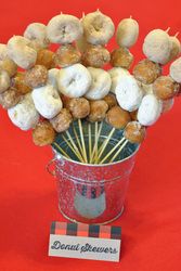 a bucket filled with donuts and skewers on top of a red table