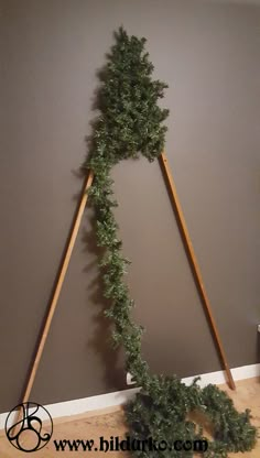 two wooden poles with plants growing out of them on top of a hard wood floor